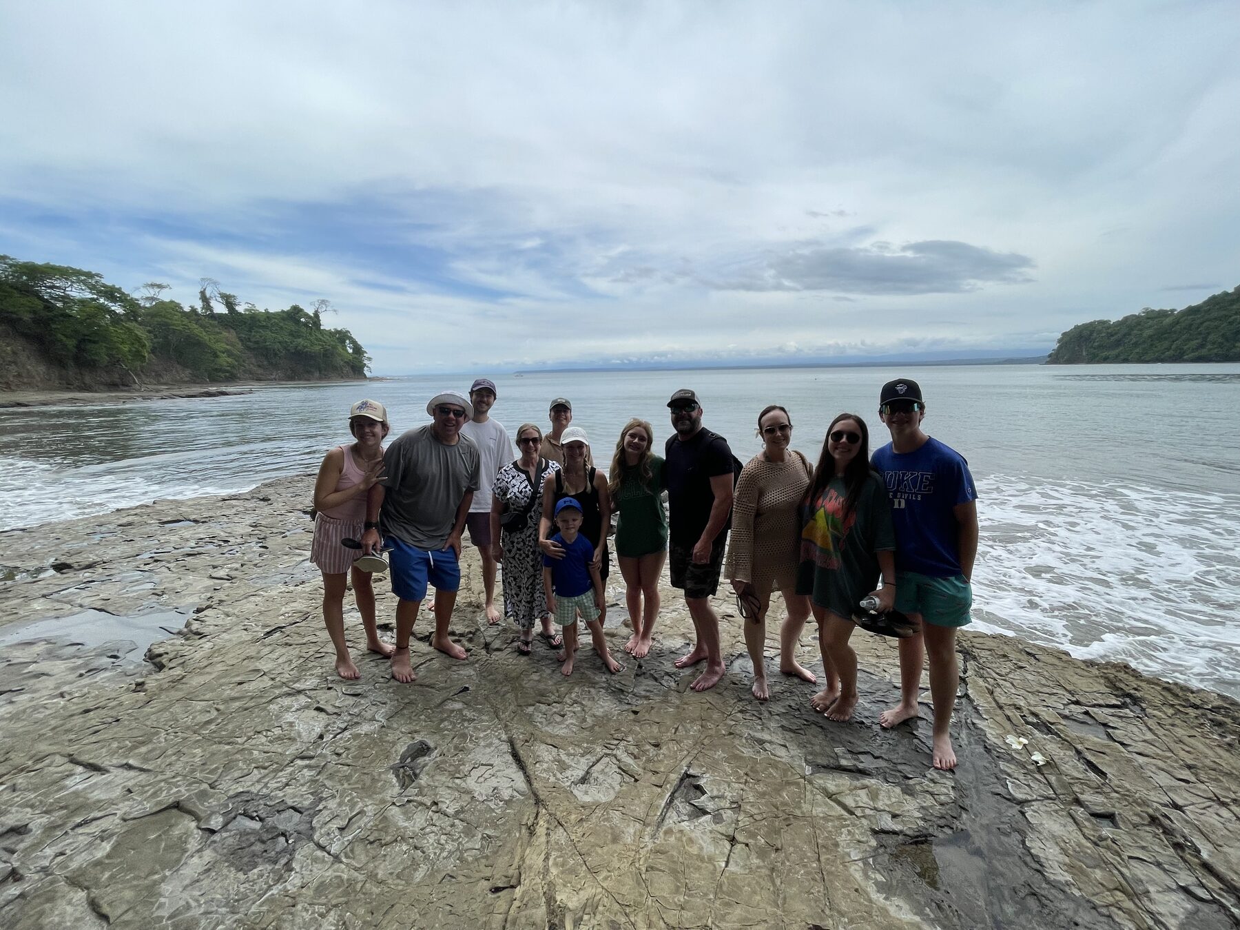A big group lined up on the rocks at the cove at Playa Mantas — Jaco Costa Rica best snorkeling