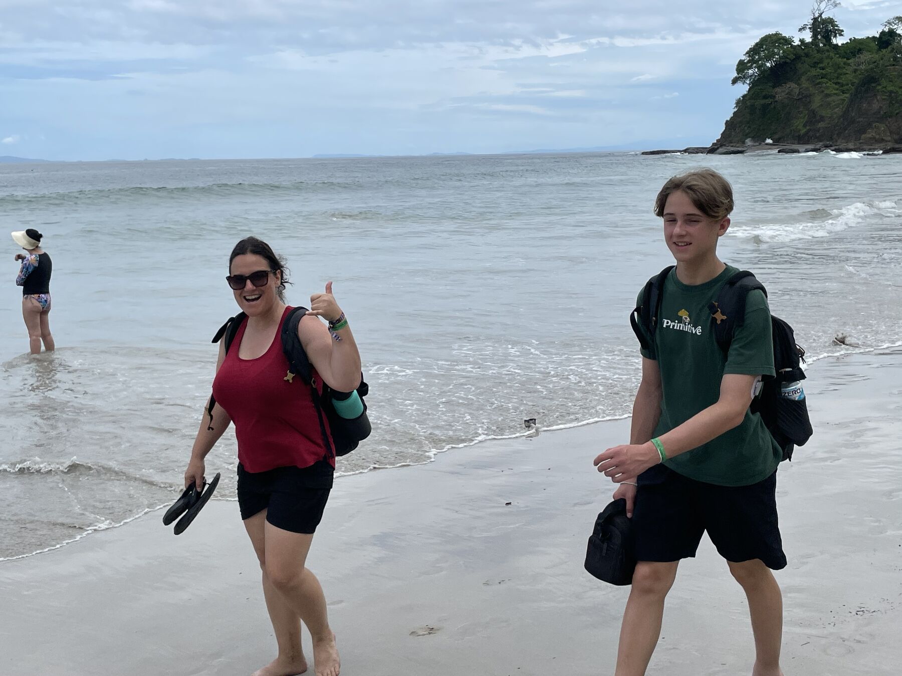 A couple walking out of the water giving a thumbs-up at Playa Mantas — Jaco Costa Rica best snorkeling