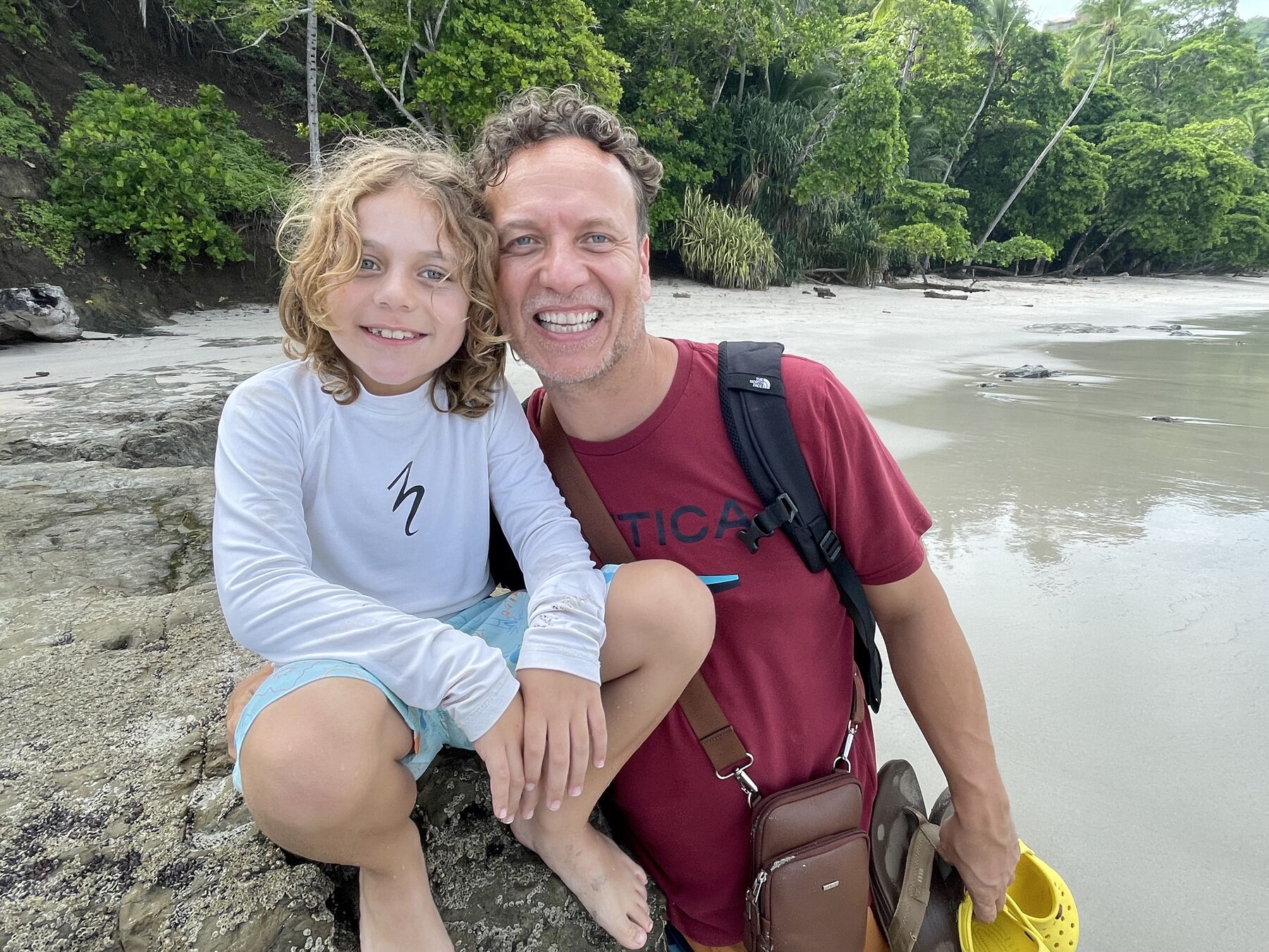 A dad and his son all smiles on the sand at Playa Mantas — top snorkel tour Jaco beach