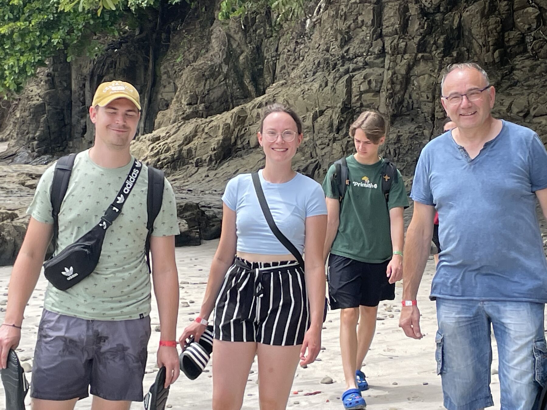 A group of four guests posing by the rocks at Playa Mantas — Jaco Costa Rica best snorkeling