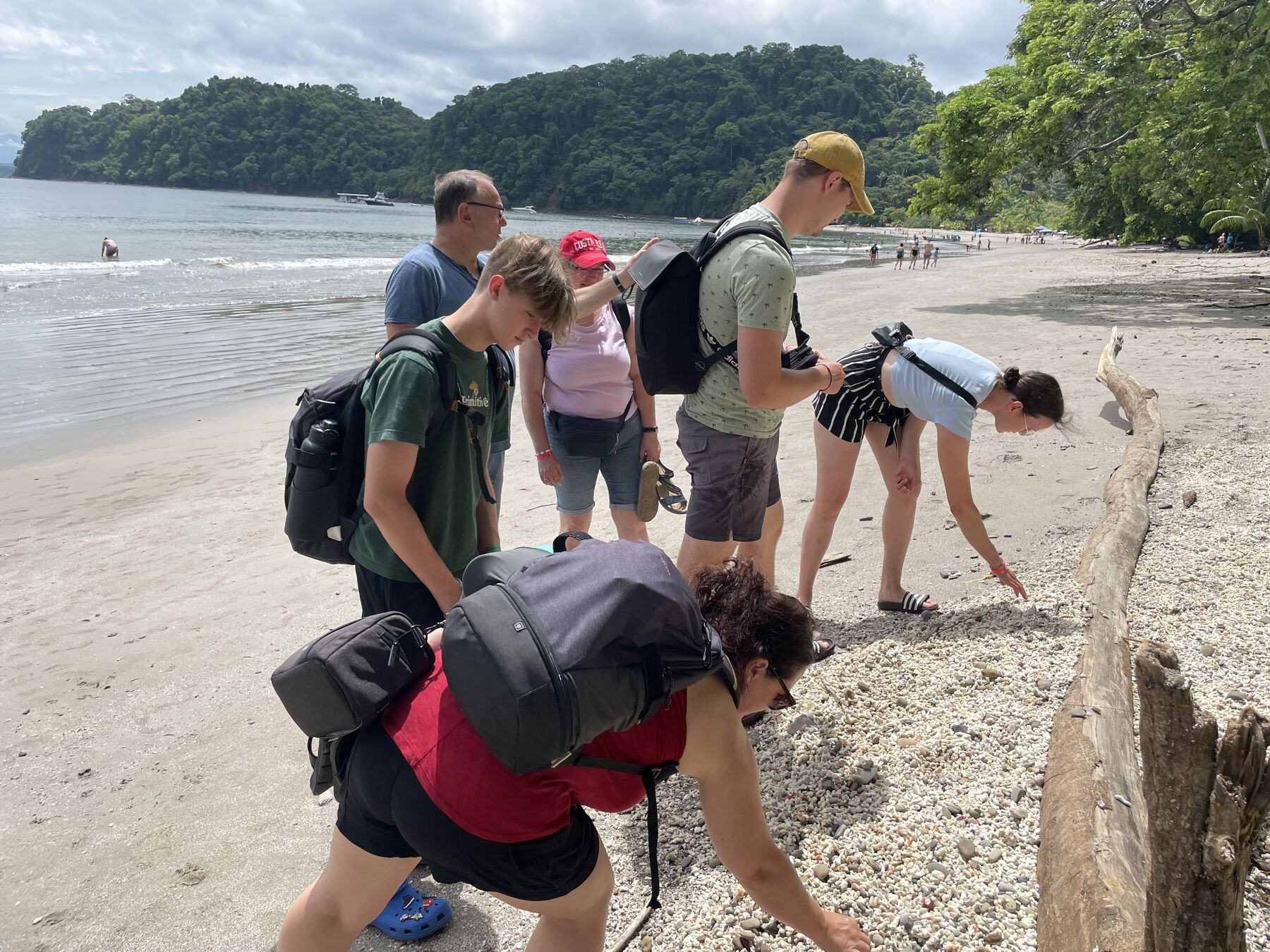 A group getting their snorkel gear ready on the sand at Playa Mantas on a best snorkel tour Jaco beach day
