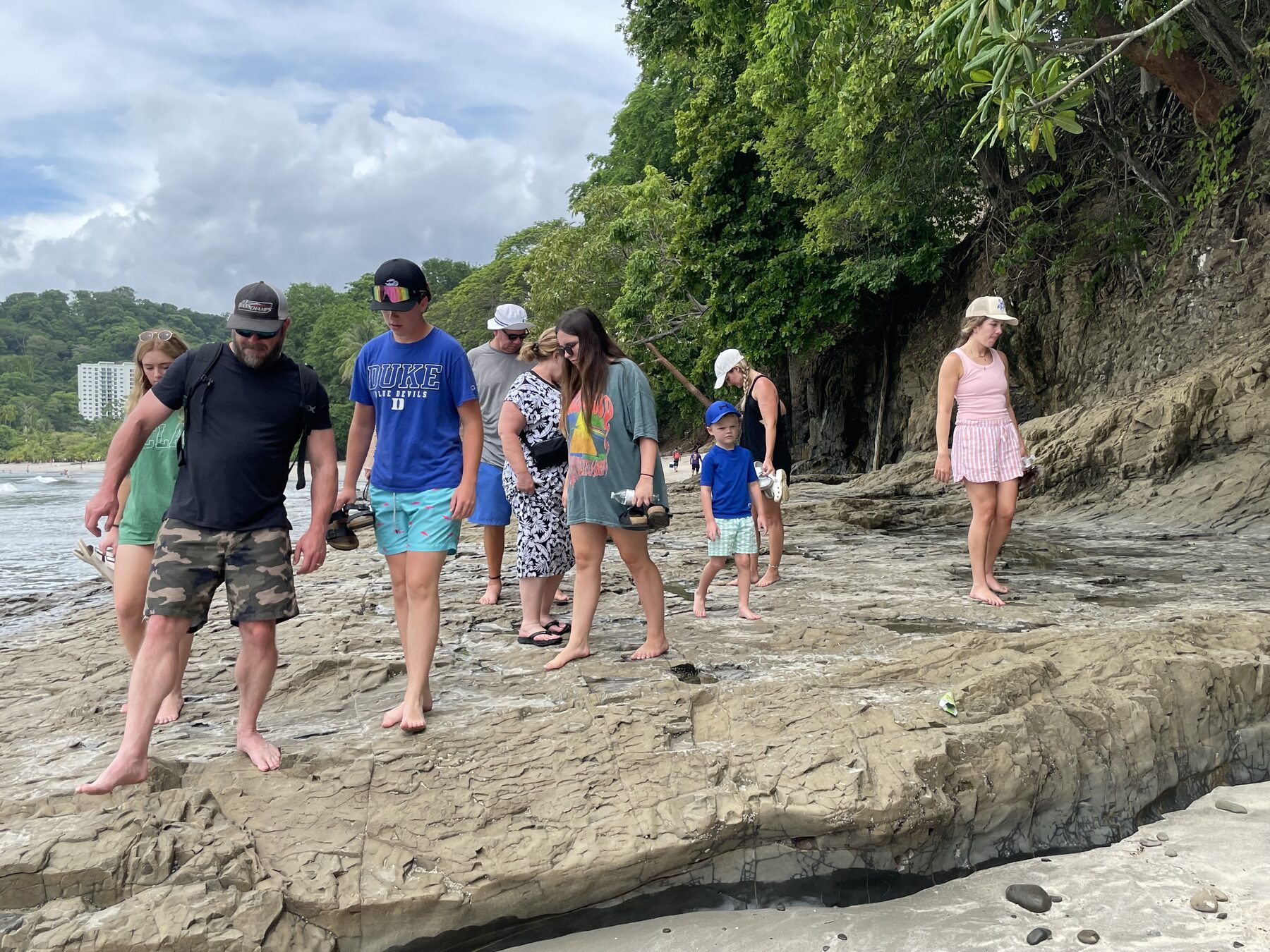 A group picking their way down the rocks to the beach at Playa Mantas — Jaco Costa Rica best snorkeling