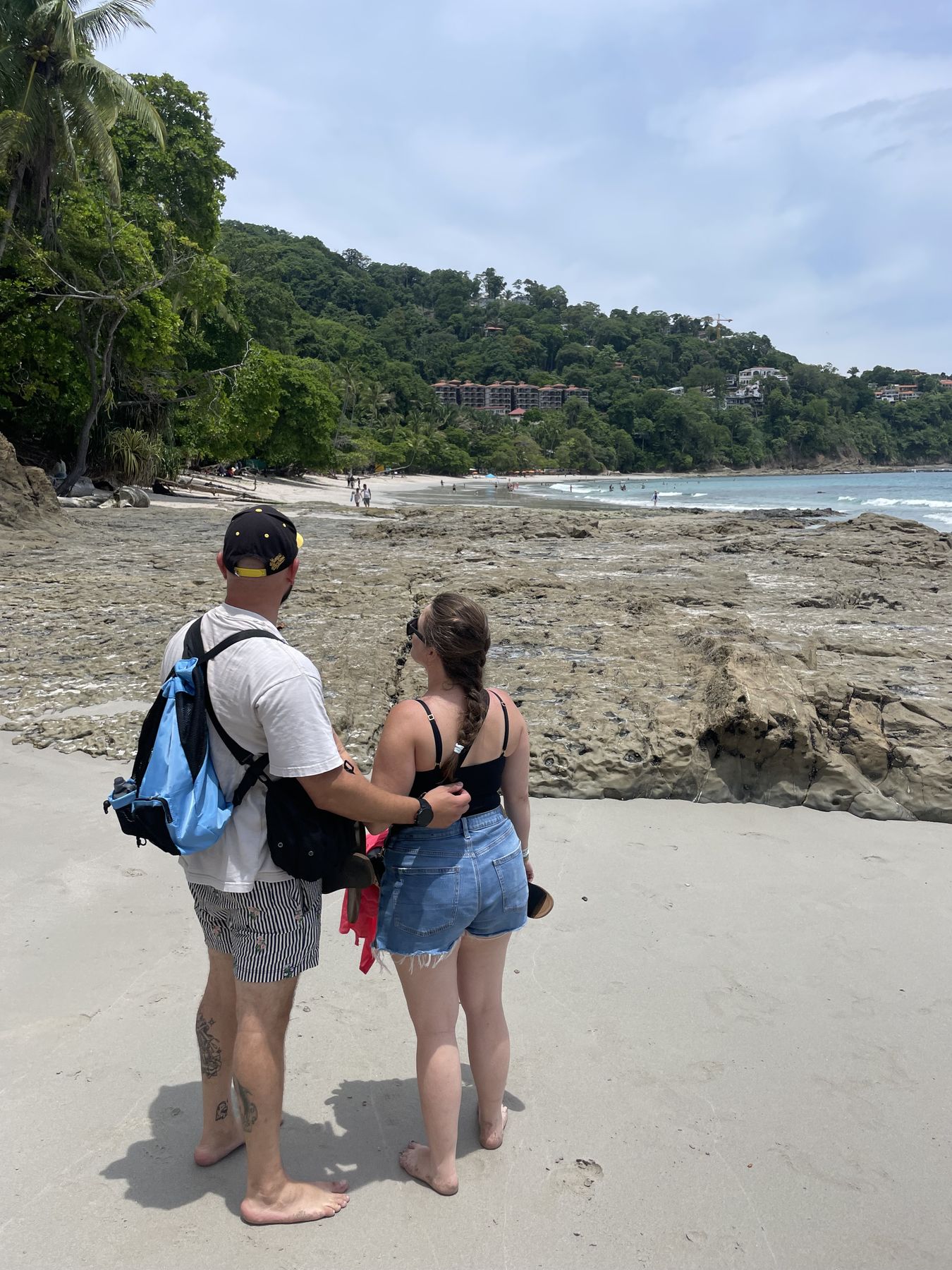 A couple on the white sand beach at the cove near Playa Mantas on their Snorkel Jaco tour