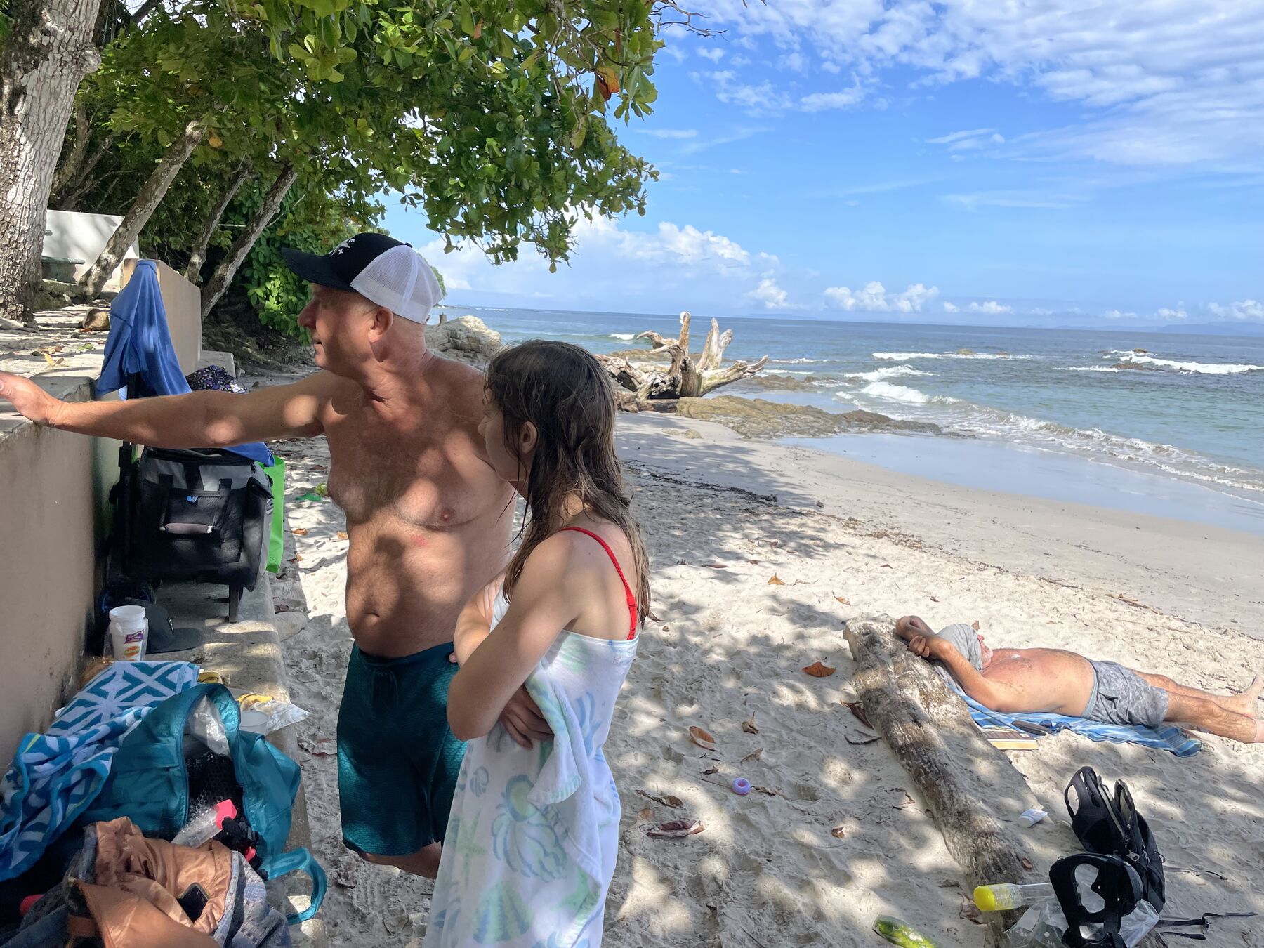 A guest pointing something out on the sand at Playa Mantas on a best snorkel tour Jaco beach day