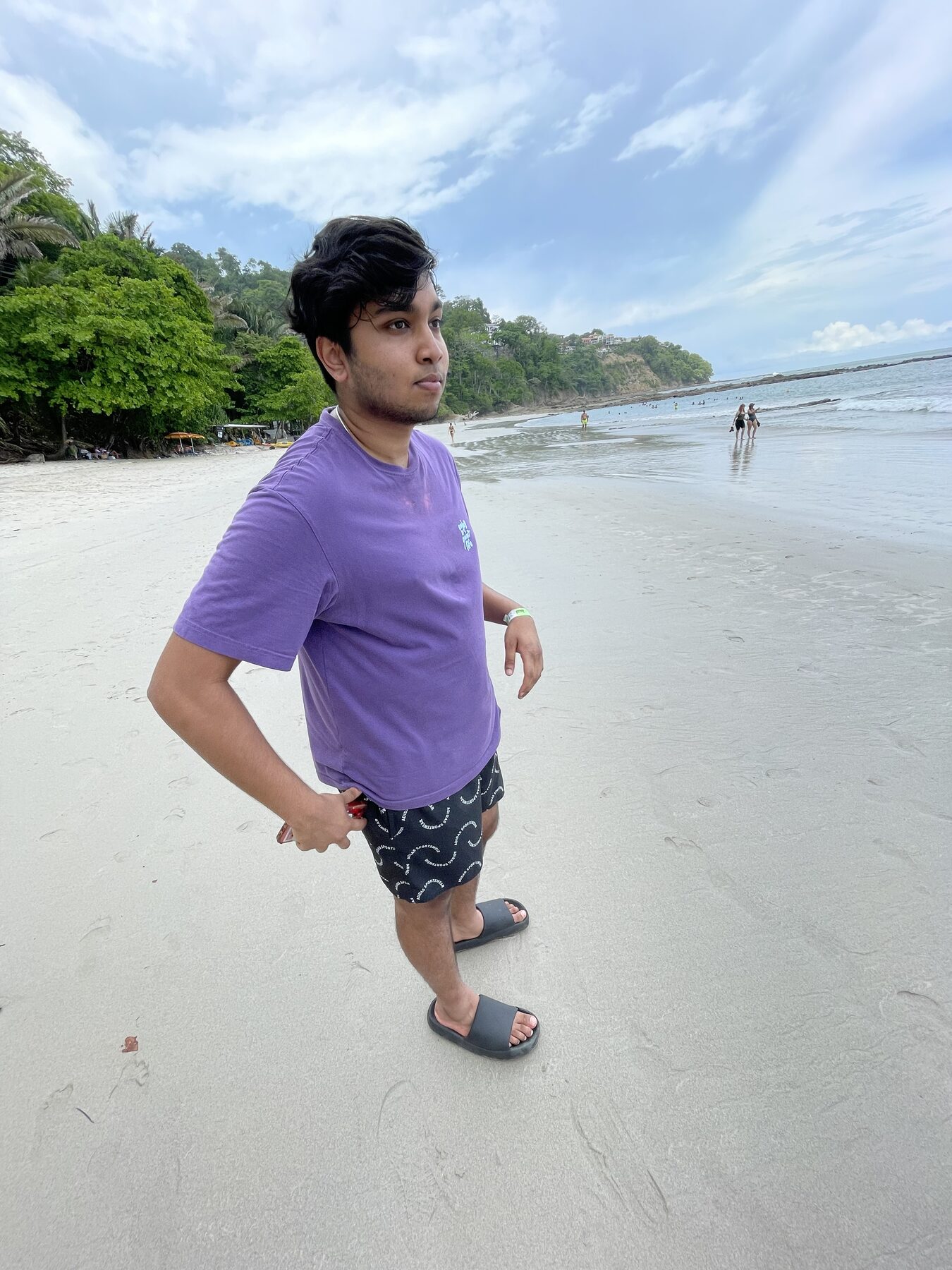 A guest on the white sand at Playa Mantas with the headland behind — top snorkel tour Jaco beach