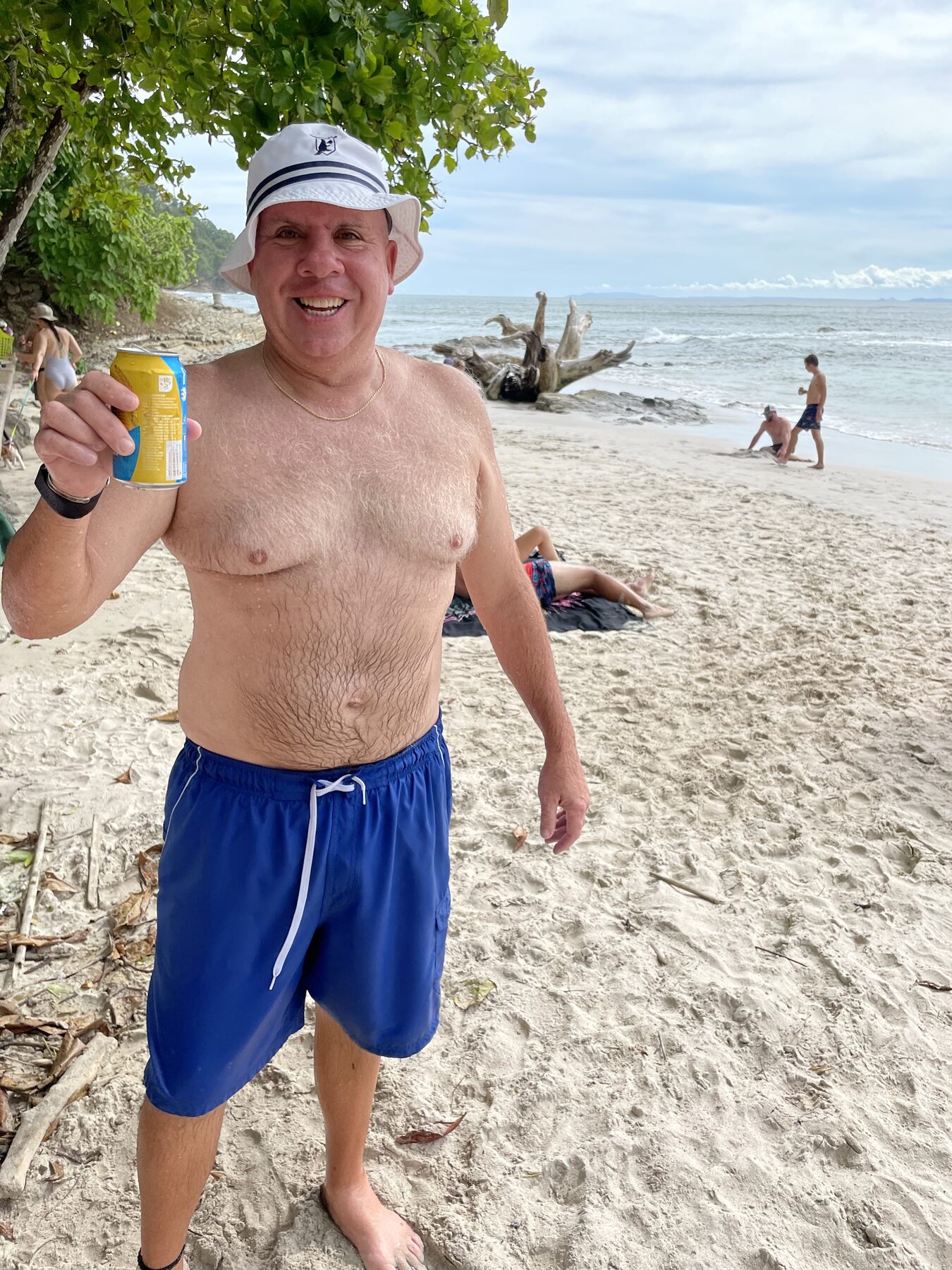 A smiling guest with a cold drink on the beach at Playa Mantas on a best snorkel tour Jaco beach day