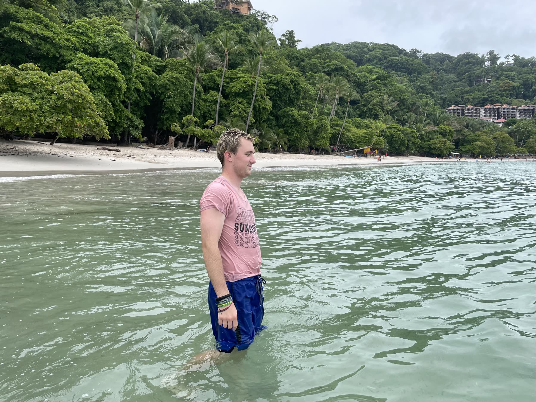 A guest at the water's edge at Playa Mantas on a best snorkel tour Jaco beach day