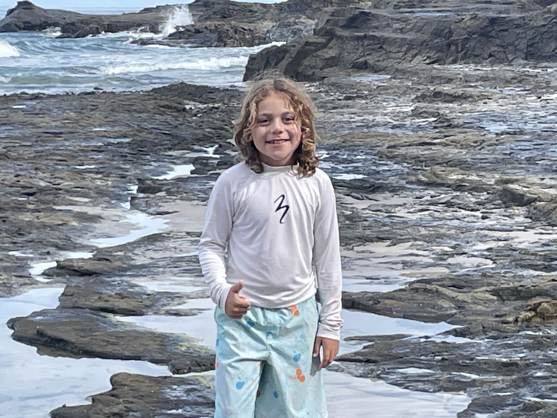A young guest smiling on the rocky reef at Playa Mantas — top snorkel tour Jaco beach