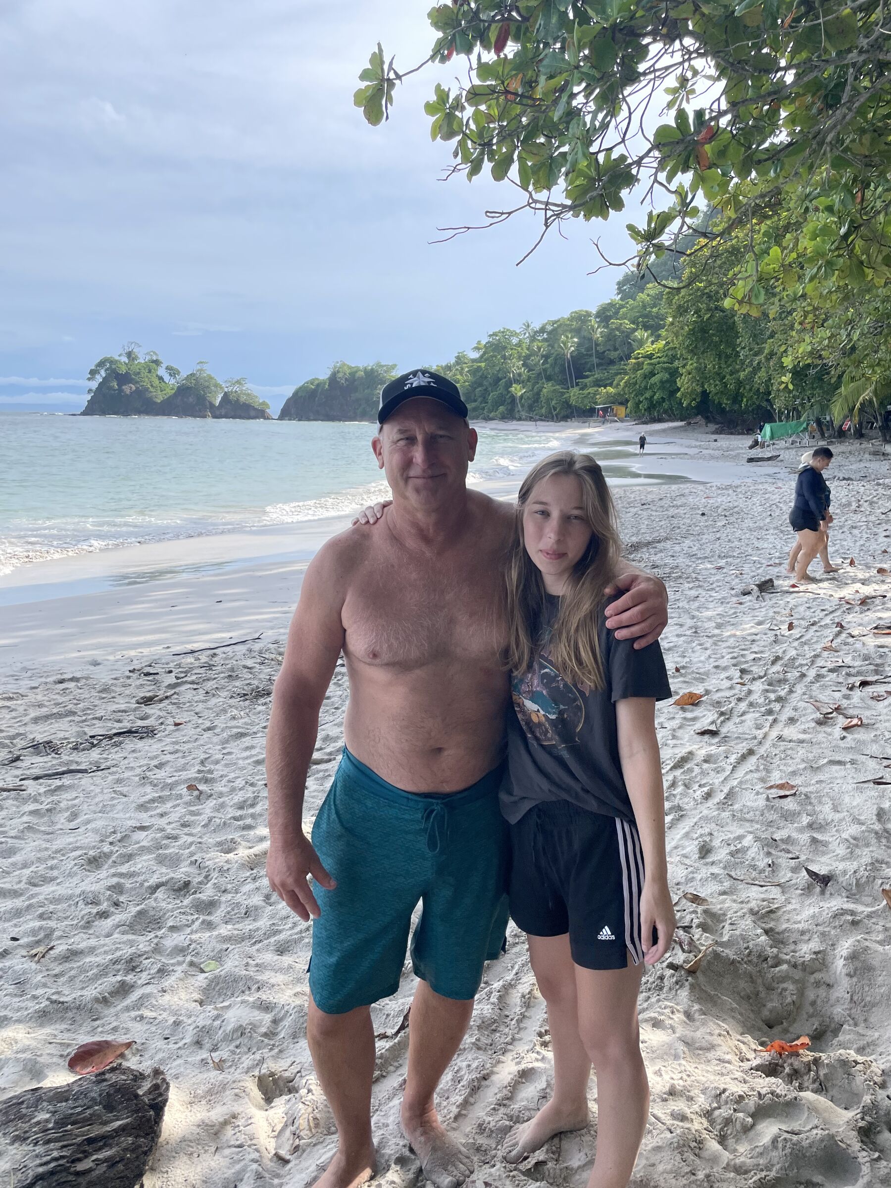 A parent and child standing together on the beach at Playa Mantas on a best snorkel tour Jaco beach day