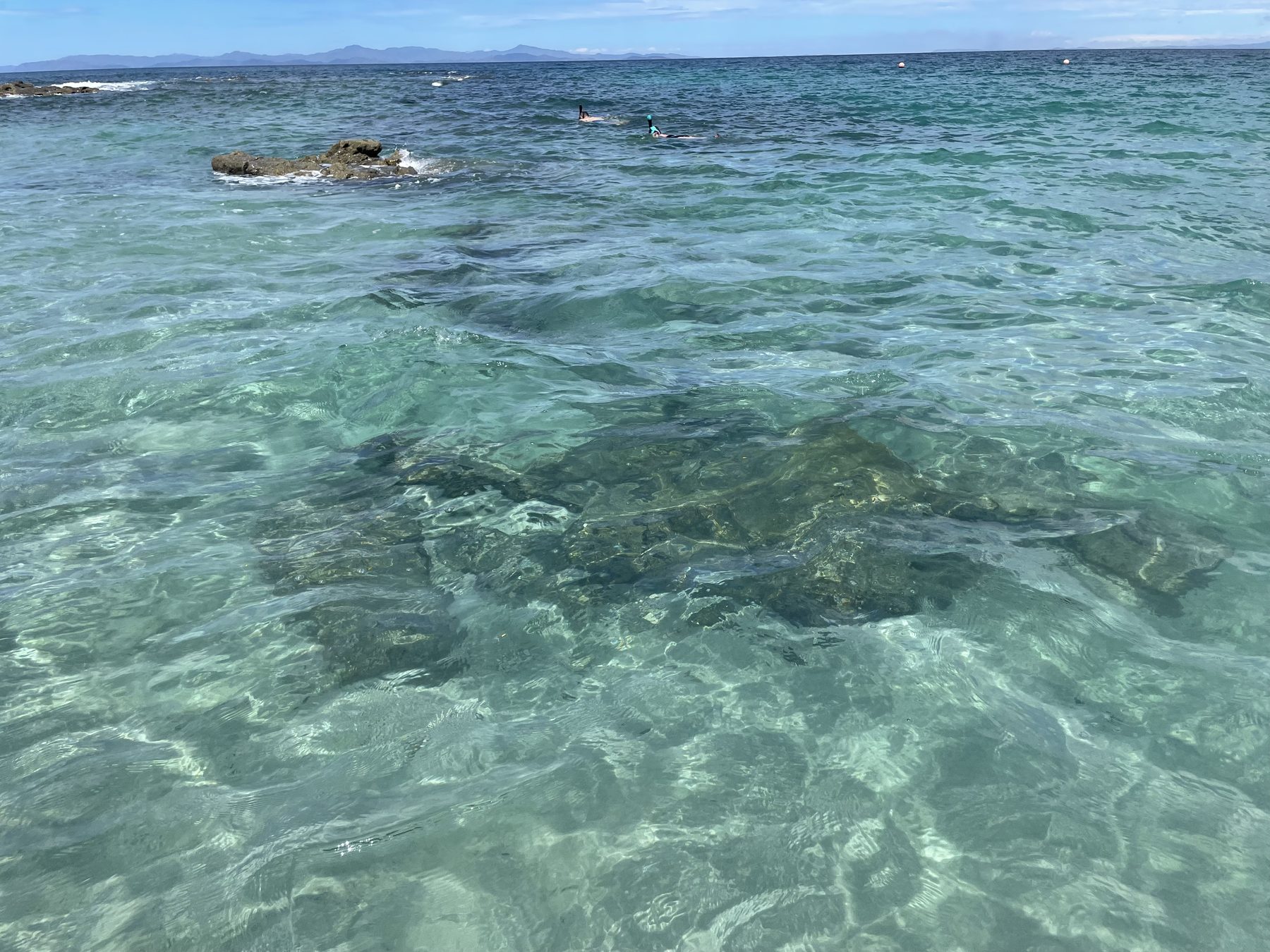 Clear, calm snorkeling water in a sheltered cove near Jacó versus busier Manuel Antonio beaches