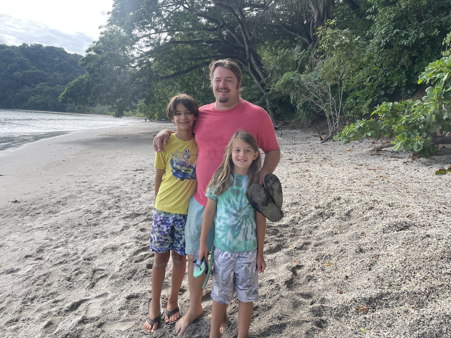 A dad and kids on the beach at Playa Mantas before Jacó beach snorkel tours