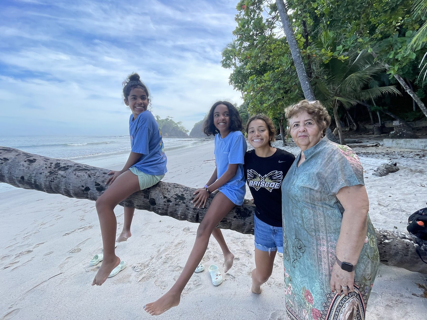 A family on a log at Playa Mantas after Jaco beach snorkeling