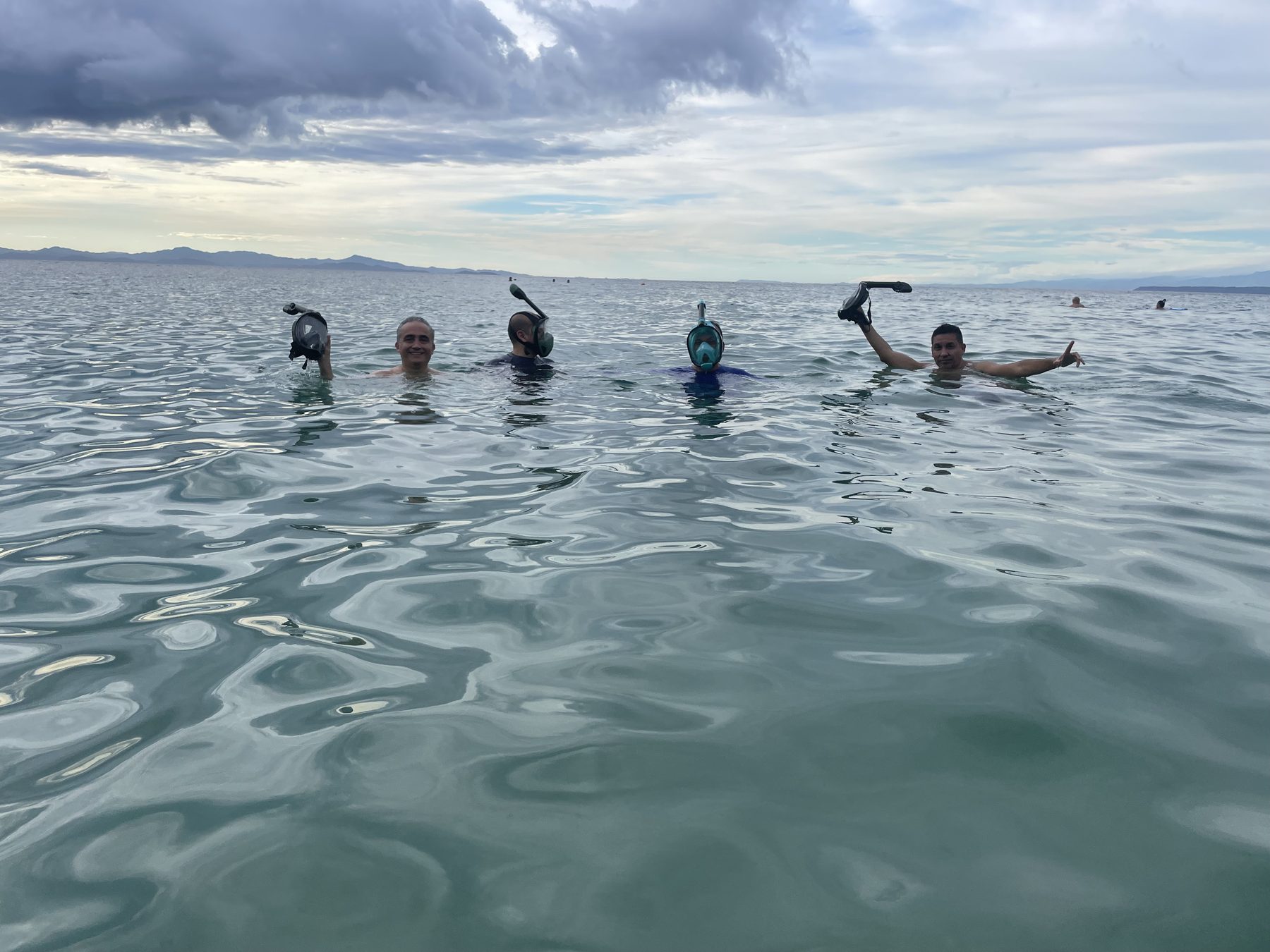 Group of snorkelers in shallow clear water at Playa Mantas near Jacó Beach, Costa Rica