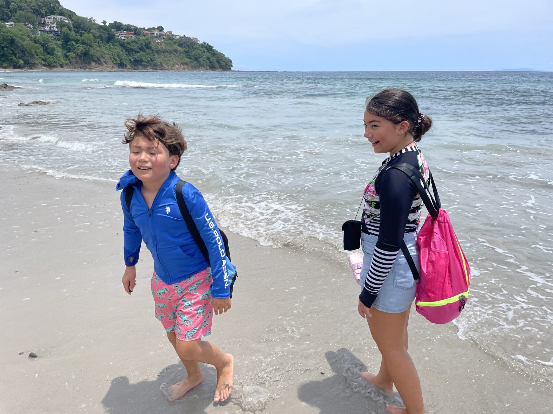 Kids in rash guards with snorkel gear on the calm, safe beach near Jacó, Costa Rica