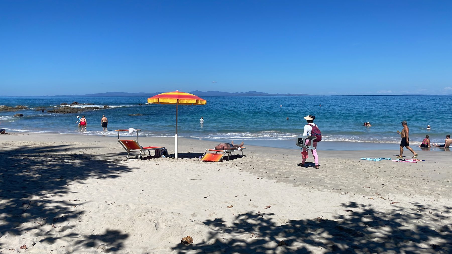 A beach umbrella on the white sand at Playa Mantas on a best snorkel tour Jaco beach day