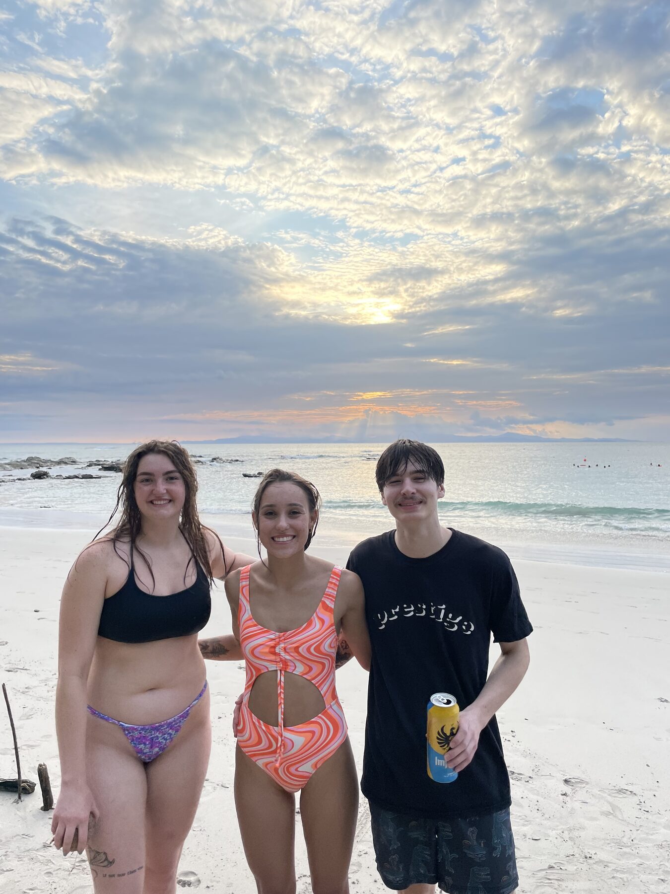 Three guests posing on the sand at golden hour at Playa Mantas — top snorkel tour Jaco beach