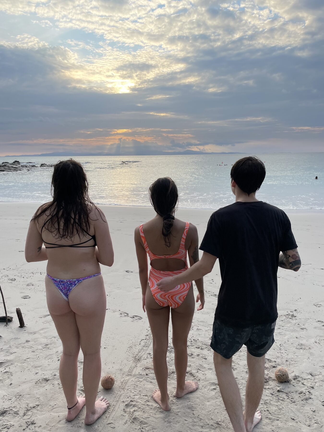 Three guests walking the sand toward the golden sky at Playa Mantas — top snorkel tour Jaco beach
