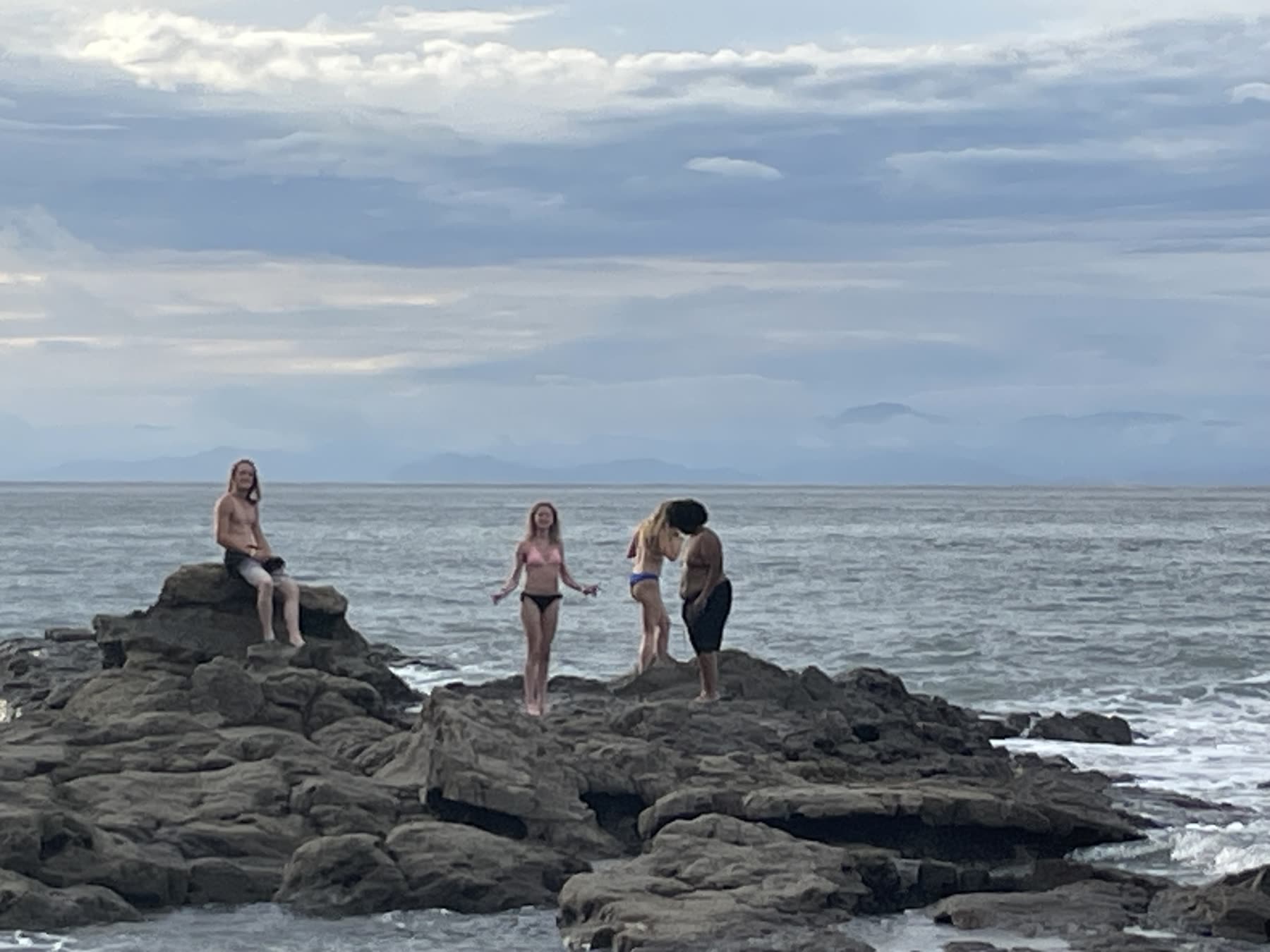 Teens on the rocky point at Playa Mantas on a best snorkel tour Jaco beach day
