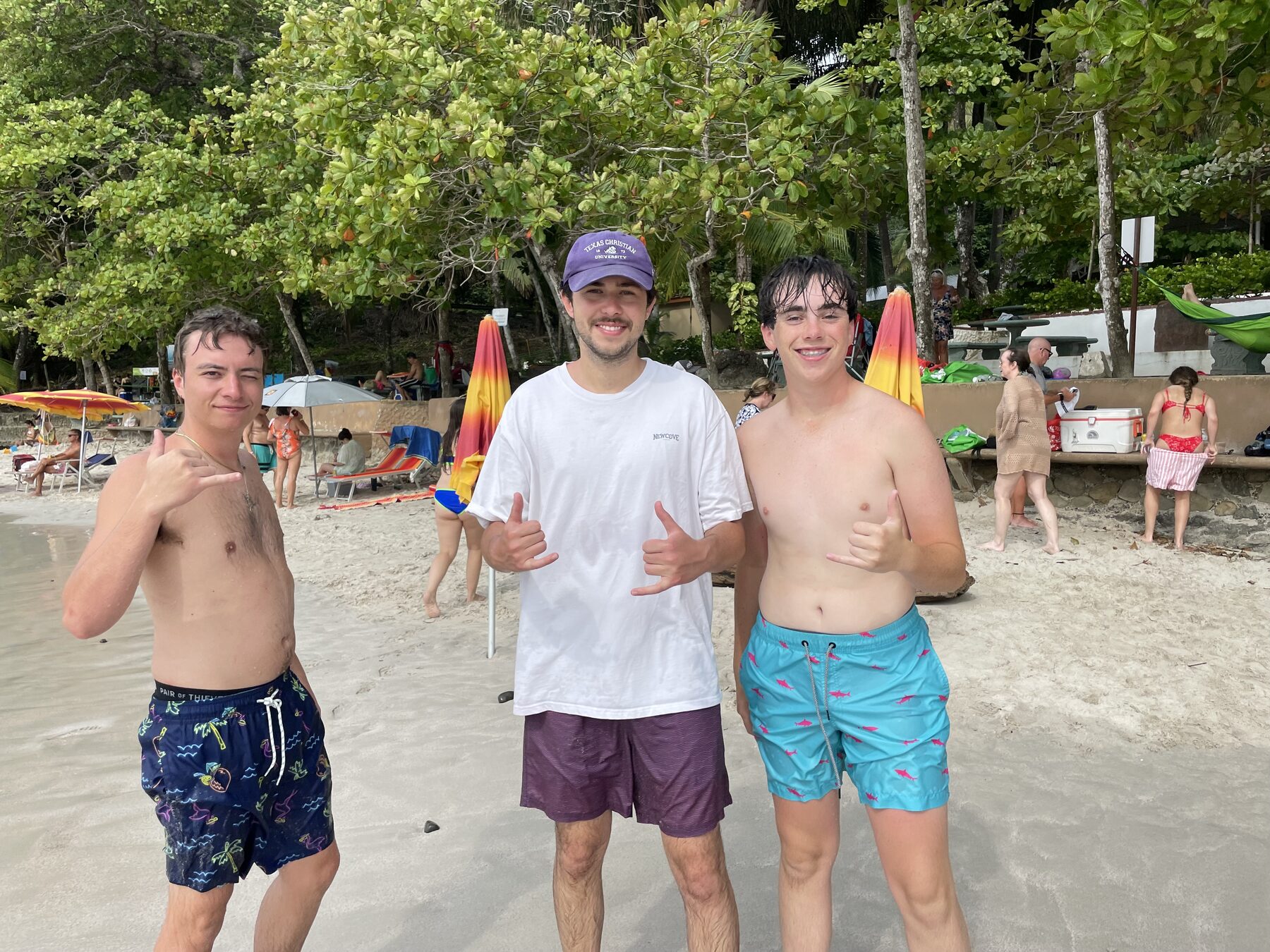 Three young guests throwing shakas on the beach at Playa Mantas — top snorkel tour Jaco beach