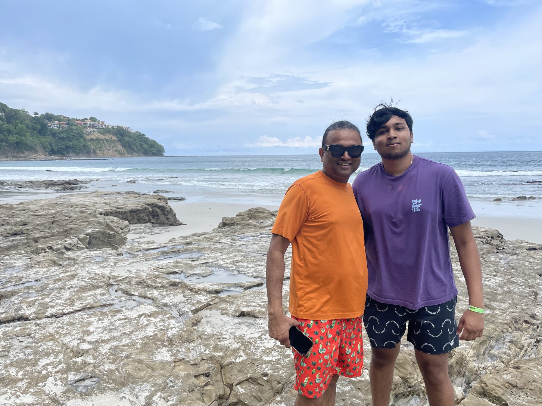 Two guests out on the headland rocks at Playa Mantas on a best snorkel tour Jaco beach day