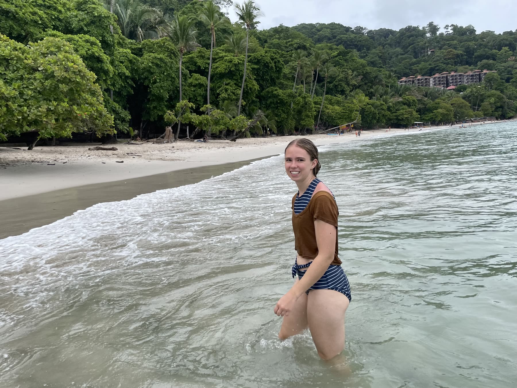 A young guest at the water's edge at Playa Mantas on a best snorkel tour Jaco beach day